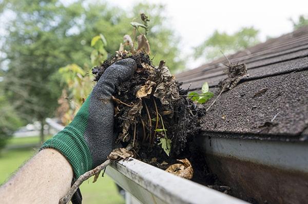 we take necessary precautions to protect the surrounding area, such as using tarps and barriers, during gutter cleaning